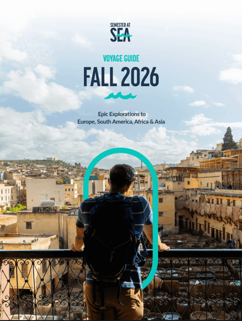 male student looking out at the city from a balcony